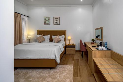 a bedroom with a bed and a desk and a bed at Quest Boutique Hotel in Gwarinpa