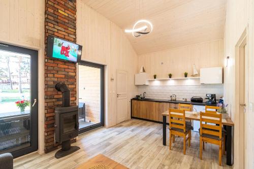 a kitchen with a table and a tv on a brick wall at Amber Domki in Jarosławiec