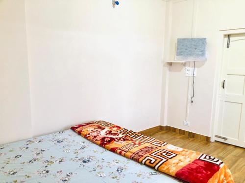 a bedroom with a bed with a blanket on the floor at Pine Hill Comfort Stay in Shillong