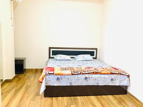 a bedroom with a bed with a wooden floor at Pine Hill Comfort Stay in Shillong