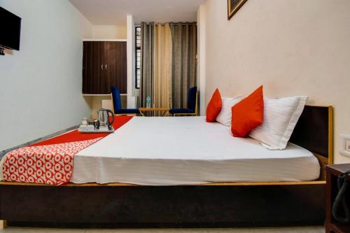 a bedroom with a large bed with orange and white pillows at Royal Retreat By Hotel Aditya Inn in Jaipur