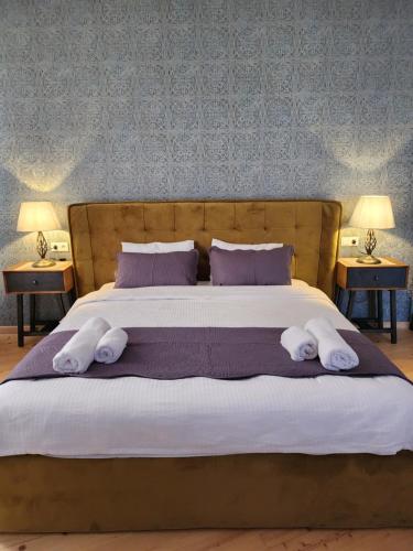 a large bed with two pillows on it with two tables at Old Gold Anteon in Tbilisi City