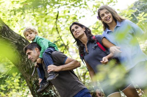 a group of people walking in the woods at Hotel Finkennest - Panoramic Garden Resort in Schenna