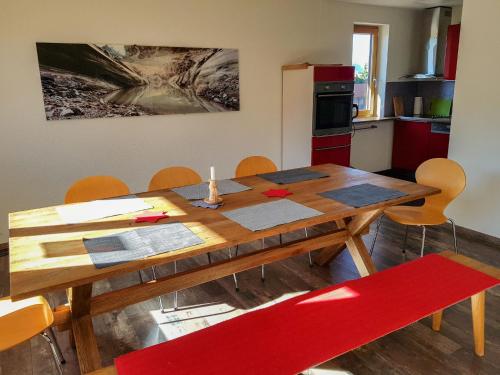 une cuisine avec une table en bois et une chaise rouge dans l'établissement Apartment Arzinol 504 by Interhome, à Les Collons