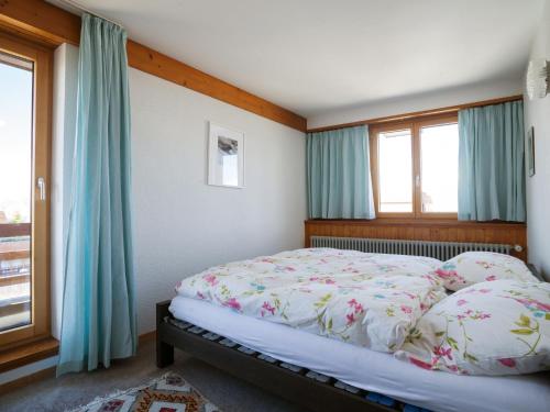 - une chambre avec un lit doté de rideaux bleus dans l'établissement Apartment Arzinol 504 by Interhome, à Les Collons