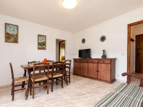 uma sala de jantar com uma mesa e uma televisão em Apartment S'Olivera-5 by Interhome em Begur