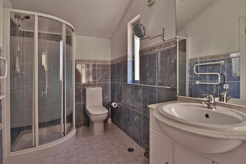 ein Bad mit einem Waschbecken, einem WC und einer Dusche in der Unterkunft Villa Quadradinhos 21Q - luxurious 4 bedroom Vale do Lobo villa with private heated pool in Vale do Lobo