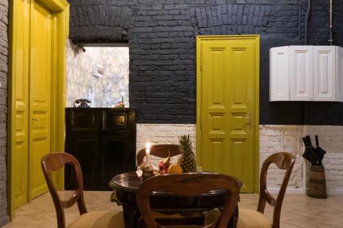 ein Esszimmer mit gelben Türen und einem Tisch mit Stühlen in der Unterkunft Metropolis Budapest Boutique Hotel in Budapest