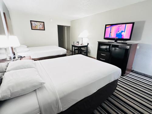 a hotel room with two beds and a flat screen tv at Econo Lodge in Ardmore