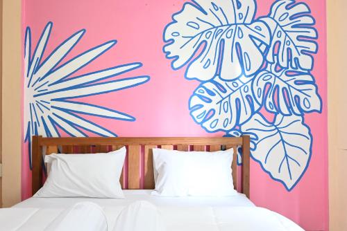 a bedroom with a pink wall with a flower mural at MARIA Guesthouse in Phra Nakhon Si Ayutthaya