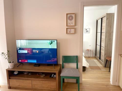 a living room with a flat screen tv on a wooden entertainment center at Metro Suites in Tirana