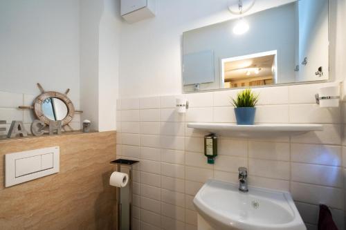 ein Bad mit einem Waschbecken und einem Spiegel in der Unterkunft Meeresrauschen in Westerland