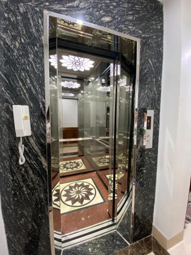 a glass elevator in a room with a black wall at Van Nam Hotel in Ha Long