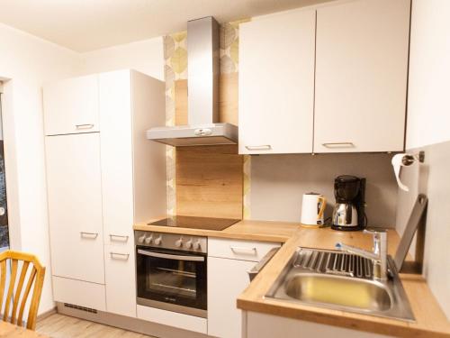 una cocina con armarios blancos y fregadero en Apartment Sonnenhof-2 by Interhome, en Kaunertal