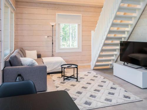 a living room with a couch and a television at Holiday Home Kitkanvee 2 by Interhome in Kuusamo
