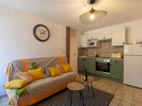 a living room with a couch and a clock on the wall at Apartment Les Manoirs de la Côte by Interhome in Varaville