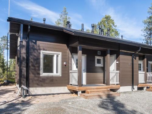 eine Blockhütte mit einer Veranda und einem Haus in der Unterkunft Holiday Home Kitkanvee 1 by Interhome in Kuusamo