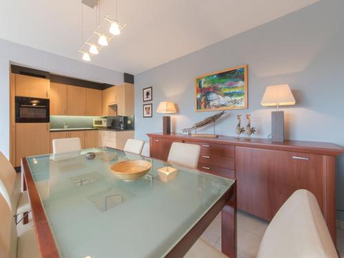 eine Küche mit einem Glastisch und weißen Stühlen in der Unterkunft Apartment Goldsands II by Interhome in De Haan
