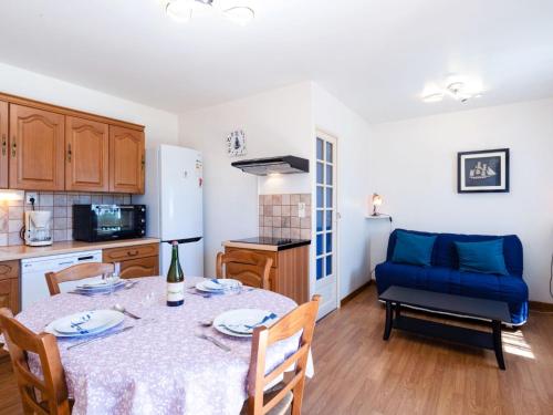 a kitchen with a table and a blue chair at Apartment Les Maisons de la Mer by Interhome in Merville-Franceville-Plage