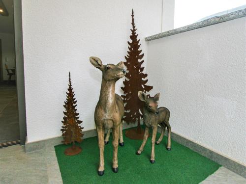 a statue of a deer and a baby deer next to christmas trees at Apartment Sonnigs Platzl by Interhome in Stumm