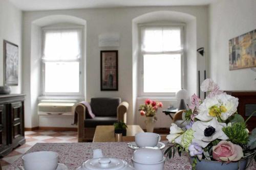 una sala de estar con una mesa con flores. en Appartamento La Contrada, en Trento