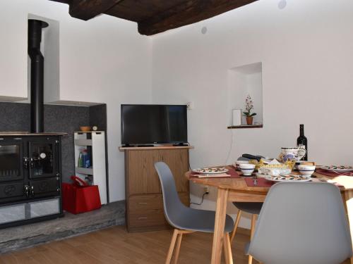une cuisine avec une table et des chaises ainsi qu'une télévision dans l'établissement Holiday Home Bertino by Interhome, à Cugnasco