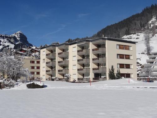 a large apartment building in the snow with a parking lot at Apartment Sunnmatt Süd Wohnung 432 by Interhome in Engelberg