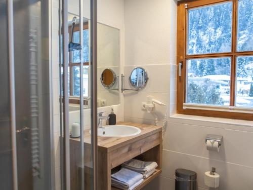a bathroom with a sink and a mirror and a window at Apartment Top 1 by Interhome in Kaunertal