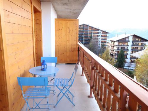 een balkon met een blauwe tafel en stoelen erop bij Apartment Grand Panorama A5 by Interhome in Nendaz