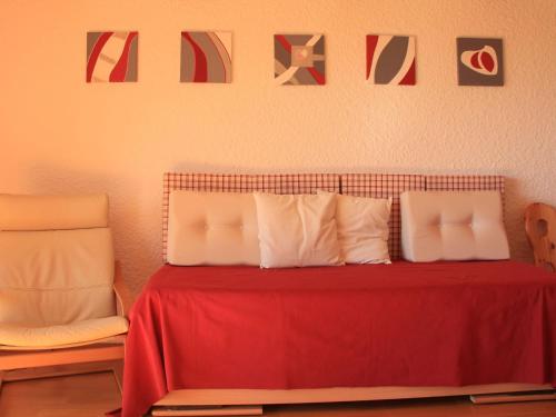 a red bed with white pillows and a red blanket at Apartment Le Bouquetin 5 by Interhome in Villars-sur-Ollon