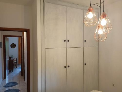 a living room with white cabinets and lights at Siviri Sea & Forest-Cozy Apartment with Garden & Nature Views in Siviri