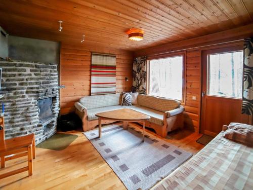 ein Wohnzimmer mit Couch und Kamin in der Unterkunft Holiday Home Mäkitupa 2 by Interhome in Kuusamo