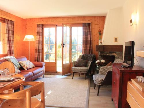 uma sala de estar com um sofá e uma lareira em Apartment Rose des Vents 4 by Interhome em Villars-sur-Ollon