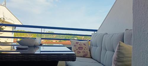 a white couch sitting on a balcony with a table at Siviri Sea & Forest-Cozy Apartment with Garden & Nature Views in Siviri