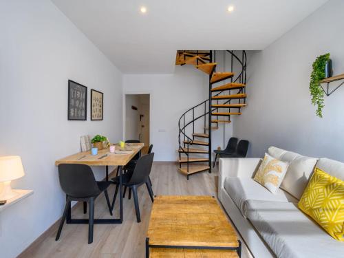un soggiorno con divano, tavolo e scala a chiocciola di Apartment Ginesta by Interhome a La Molina
