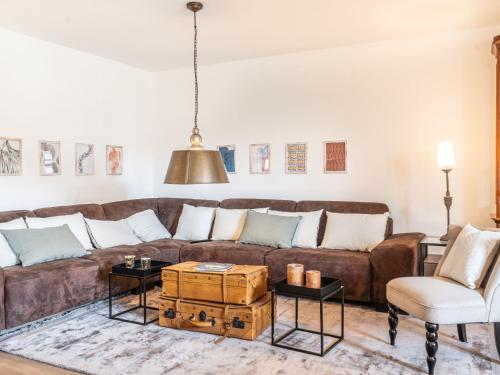 sala de estar con sofá marrón y silla en Holiday Home Haus Katschberg 8 by Interhome en Rennweg