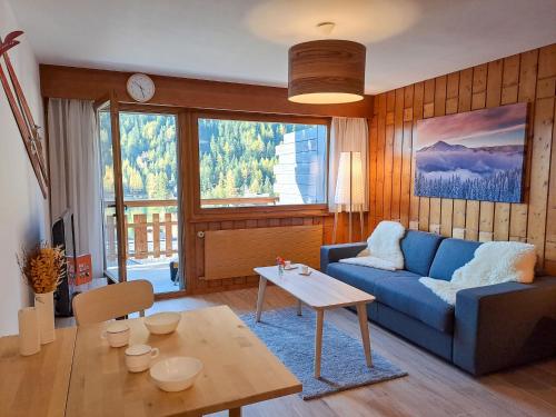 ein Wohnzimmer mit einem blauen Sofa und einem Tisch in der Unterkunft Apartment Parc B428 by Interhome in Champex