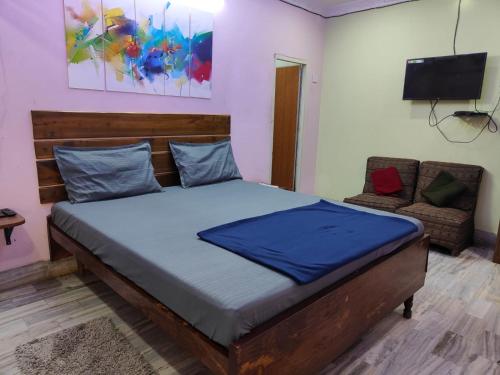 ein Schlafzimmer mit einem großen Bett und einem Sofa in der Unterkunft Hotel HCB (Hemo Chandra Bhawan) in Brahmapur
