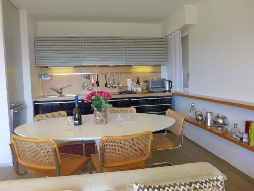 a kitchen with a table and chairs in a kitchen at Apartment Clair-Azur-3 by Interhome in Crans-Montana