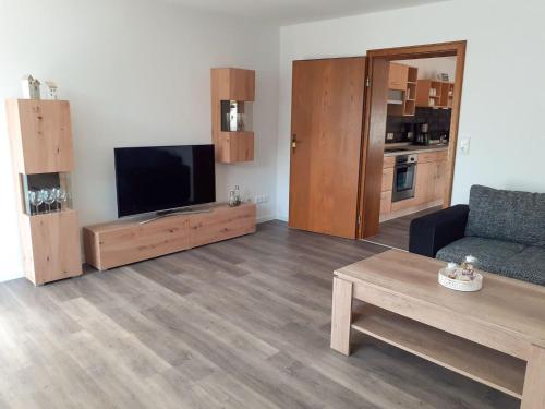 sala de estar con TV de pantalla plana y sofá en Apartment Am Meintetal by Interhome en Lügde