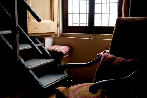 a room with stairs and a chair and a window at Antica Corte Pallavicina Relais in Polesine Parmense