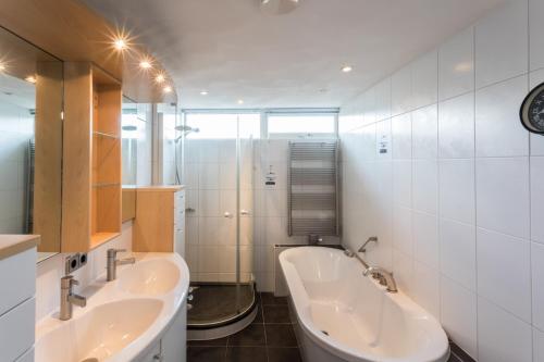 a bathroom with two sinks and a shower at Hello Zeeland - Appartement Loverendale 31 in Domburg