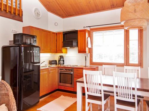 eine Küche mit einem Tisch und einem schwarzen Kühlschrank in der Unterkunft Holiday Home Tahkon klubitie 6 a by Interhome in Tahkovuori