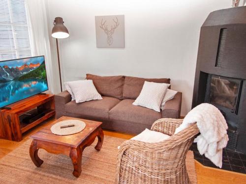 ein Wohnzimmer mit einem Sofa und einem TV in der Unterkunft Holiday Home Tahkon klubitie 6 a by Interhome in Tahkovuori