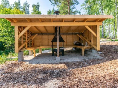 a wooden pavilion with a stove in the woods at Holiday Home Hot pool cottage kesäranta by Interhome in Ihamaniemi