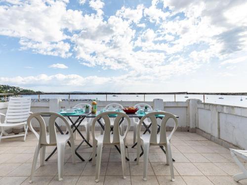 stół i krzesła na balkonie z widokiem na wodę w obiekcie Apartment Les Araucarias by Interhome w Cannes