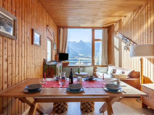 a living room with a wooden table and a large window at Apartment Le Grande Motte - Le Lac by Interhome in Tignes