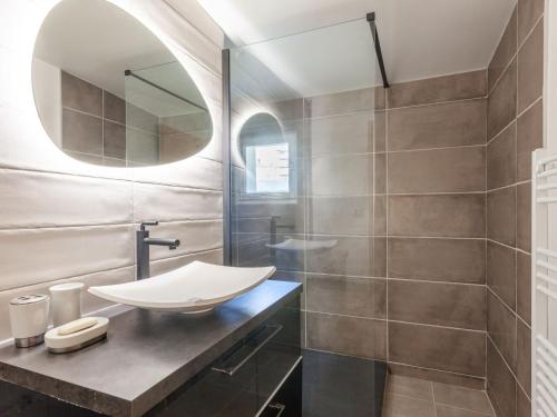 une salle de bain avec un lavabo et un miroir dans l'établissement Apartment Le Grande Motte - Le Lac by Interhome, à Tignes