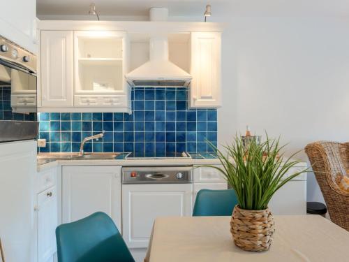 une cuisine avec des armoires blanches et une table avec une plante dans l'établissement Studio Les Pins-4 by Interhome, à Carnac