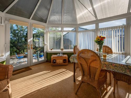 a dining room with a table and chairs and windows at Holiday Home Sullivan by Interhome in Drumnadrochit
